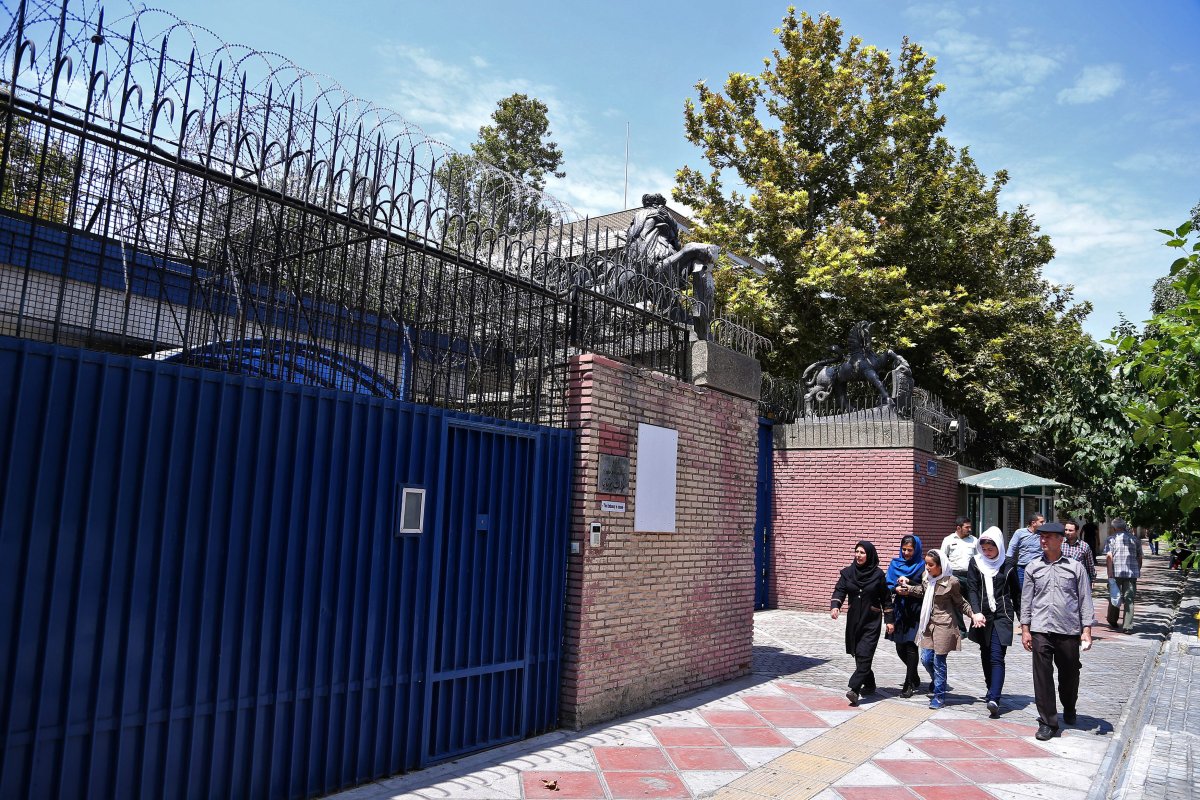 Iranian pedestrians walk past the main gate of British Embassy in Tehran, Iran, Saturday, Aug. 22, 2015. Iranian state-run media has reported the British Embassy in Tehran will reopen Sunday. The embassy has been closed for almost four years after hard-liners protesting the imposition of international sanctions over Irans contested nuclear program stormed it in November 2011.