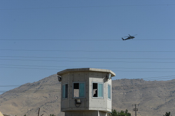 A UH-60 Black Hawk helicopter flies over the site of a suicide attack in a compound in Kabul on July 22, 2014. 