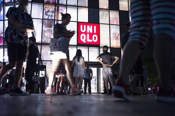 In this picture taken on July 15, 2015, people gather in front of a Uniqlo clothes store in Beijing. Chinese Communist authorities have said the distribution of a sex tape purportedly shot in a fitting room in one of Beijing's trendiest shopping malls is "against socialist core values", after the footage went viral.   