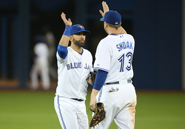 Jose Bautista #19 of the Toronto Blue Jays celebrates their victory with Justin Smoak #13 during MLB game action against the Oakland Athletics on August 11, 2015 at Rogers Centre in Toronto, Ontario, Canada. (Photo by Tom Szczerbowski/Getty Images).