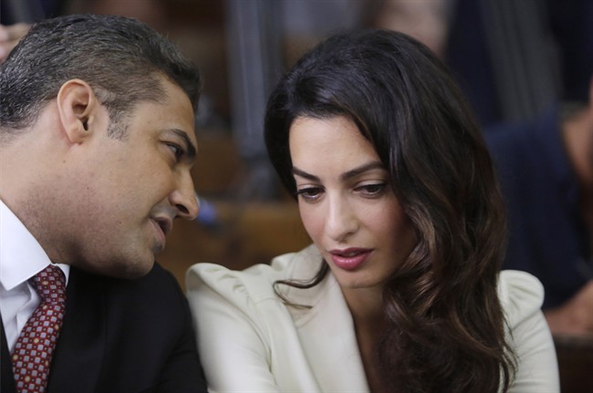 Canadian Al-Jazeera English journalist Mohamed Fahmy, left, talks to human rights lawyer Amal Clooney before his verdict in a courtroom in Tora prison in Cairo, Egypt, Saturday, Aug. 29, 2015.