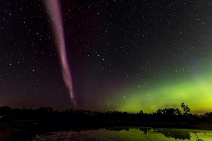 Anna Michele Mccue captured this aurora photo on Sunday August 16, 2015.  Bright green sheets of aurora can be seen along side a bright purple aural arc.