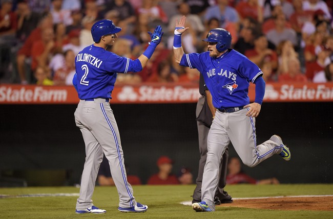 Toronto Blue Jays' Josh Donaldson, right, is congratulated by Troy Tulowitzki after scoring on a triple by Jose Bautista during the fourth inning of a baseball game, Saturday, Aug. 22, 2015, in Anaheim, Calif.