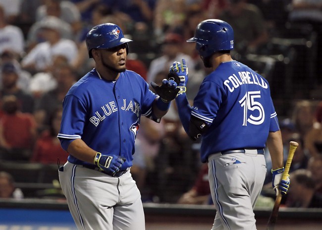 Toronto Blue Jays' Edwin Encarnacion, left, is congratulated by Chris Colabello (15) on his solo home run off of Texas Rangers' Derek Holland during the sixth inning of a baseball game Tuesday, Aug. 25, 2015, in Arlington, Texas.