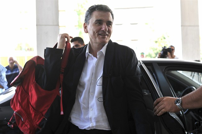 In this Friday, July 31, 2015 file photo, Greek Finance Minister Euclid Tsakalotos arrives for a meeting with senior negotiators at a hotel in Athens. Greece has essentially concluded its bailout talks with its creditors, with just a few details remaining for the deal to be formally clinched, Greek officials said Tuesday, Aug. 11. (Giannis Kotsiaris/InTime News via AP, File).