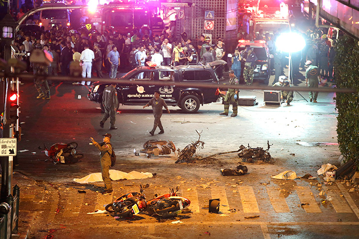 A policeman photographs debris from an explosion in central Bangkok, Thailand, Monday, Aug. 17, 2015.