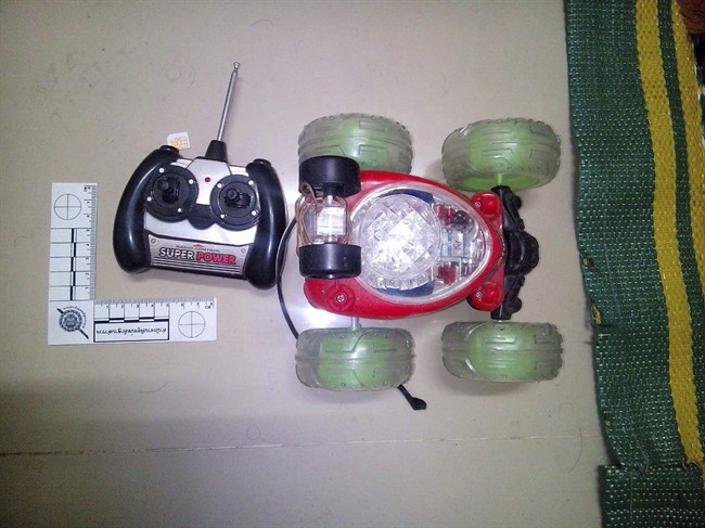 This image released Monday, Aug. 31, 2015, by the National Council for Peace and Order (NCPO) shows what police said is evidence found at the second apartment which was raided by authorities in Min Buri, in Bangkok's outskirts. Police said they found fertilizer, gun powder, digital clocks and remote-controlled cars whose parts can be used for detonation. Thai police said Monday they were seeking two new suspects - a Thai woman and a foreign man of unknown nationality - in the widening investigation into Bangkok's deadly bombing two weeks ago. Words in Thai say "Police Evidence Investigations Department." (National Council for Peace and Order via AP).