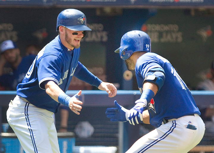 Jose Bautista is met by teammate Josh Donaldson after Bautista hit a two-run home run against the New York Yankees in the third inning of their AL baseball game in Toronto on Sunday, August 16, 2015. 