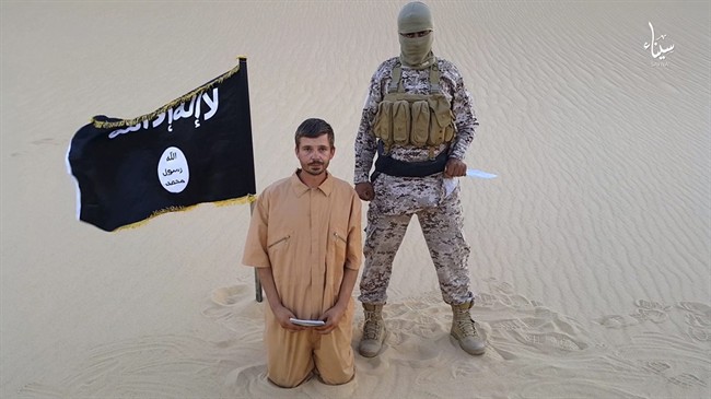 This image made from a militant video posted on a social media site on Wednesday, Aug. 5, 2015, shows a militant standing next to 30-year-old Tomislav Salopek, kneeling down as he reads a message at an unknown location. An online image purports to show the Croatian hostage being held by an Islamic State affiliate in Egypt has been beheaded.