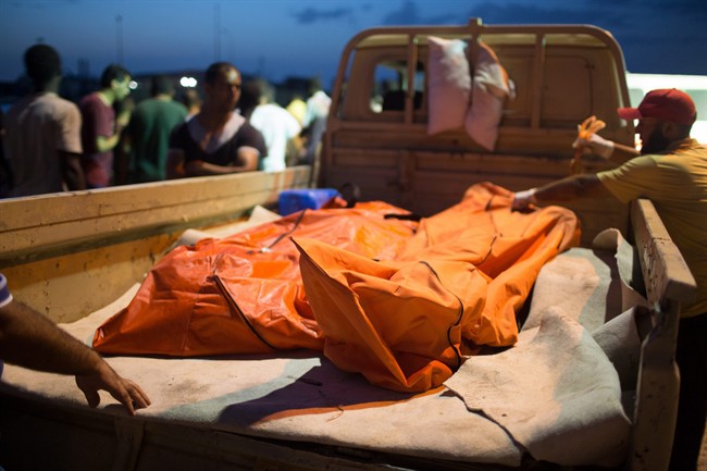 In this Thursday, Aug. 27, 2015 photo, bodies of migrants are taken from the scene of a capsized boat in Zuwara, Libya. (AP Photo/Mohamed Ben Khalifa).