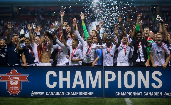 Vancouver Whitecaps players hoist the Voyageurs Cup trophy after defeating the Montreal Impact to win the Canadian Championship final soccer action in Vancouver, B.C., on Wednesday August 26, 2015.