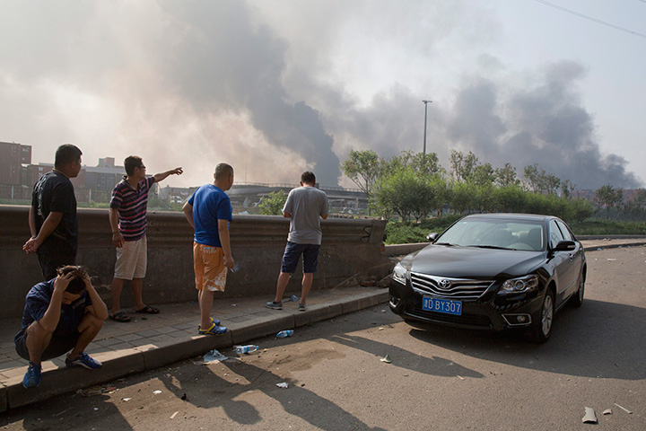 Residents gather near the site of an explosion at a port in northeastern China's Tianjin municipality, Thursday, Aug. 13, 2015. 