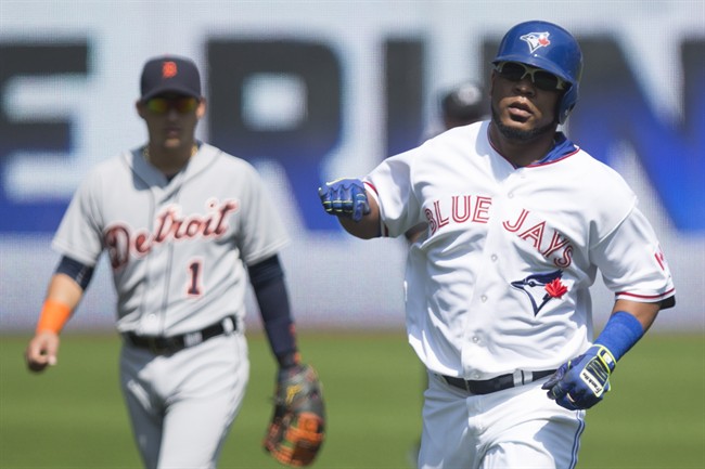 Toronto Blue Jays Edwin Encarnacion (right) rounds the bases after hitting a solo home run off Detroit Tigers starting pitcher Alfredo Simon as Tigers' shortstop Jose Iglesias (left) looks on during first inning Major League baseball action in Toronto on Sunday, August 30 , 2015.