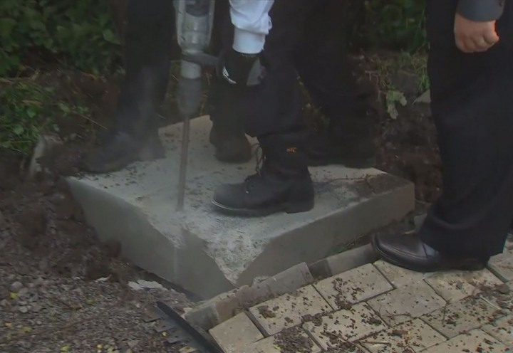 Montreal Mayor Denis Coderre takes a drill to a concrete slab meant for Canada Post community mailboxes, Thursday, August 13, 2015.