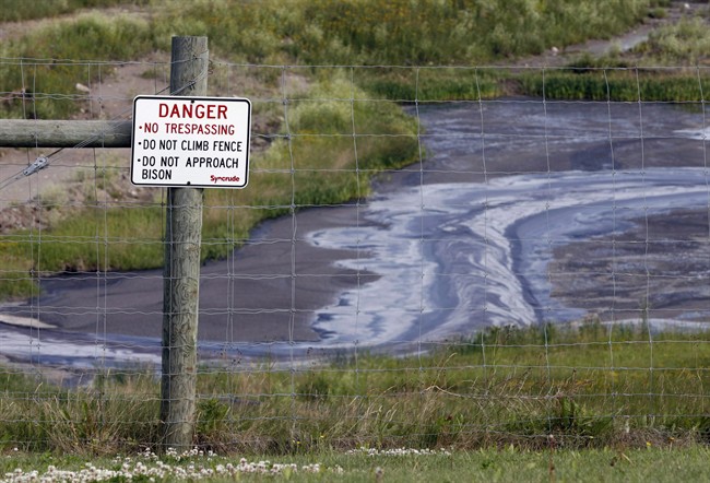 FILE -- Tailings drain into a pond at the Syncrude oilsands mine facility near Fort McMurray, Alta., Wednesday, July 9, 2008.