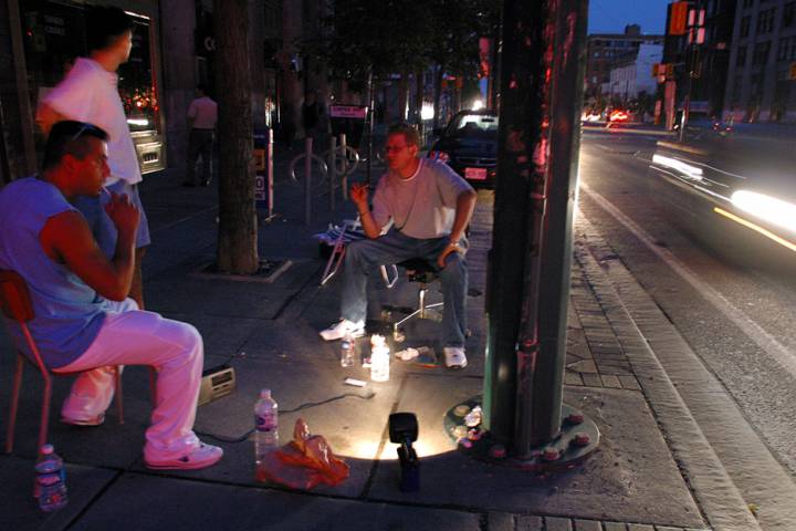 Chris Litras, right, sits outside his shop in downtown Toronto on Aug. 14, 2003, to keep an eye on things until the power came back on during a blackout that affected parts of Canada and the North Eastern United States.
