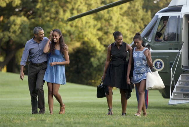 From left, President Barack Obama with daughter Malia and first lady Michelle Obama with daughter Sasha, walk form Marine One across the South Lawn of the White House in Washington, Sunday, Aug. 23, 2015, as they return form a family vacation on Martha’s Vineyard. (AP Photo/Carolyn Kaster).