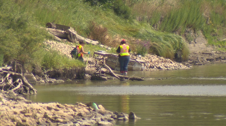 Volunteers search the banks of the Red River for evidence that could bring missing men or women home .