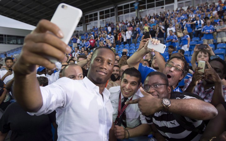 The Montreal Impact's newest player Didier Drogba takes a selfie with fans following a news conference in Montreal, Thursday, July 30, 2015.