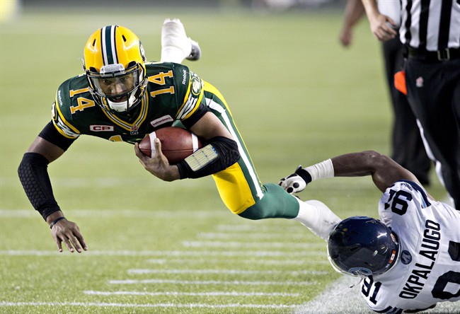 Toronto Argonauts Tristan Okpalaugo (91) trips up Edmonton Eskimos quarterback James Franklin (14) during second half action in Edmonton, Alta., on Friday August 28, 2015. 