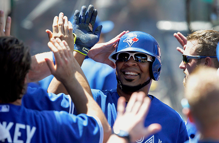 Toronto Blue Jays’ Edwin Encarnacion is congratulated by teammates after scoring against the Los Angeles Angels in Anaheim, Calif., Sunday, Aug. 23, 2015. 