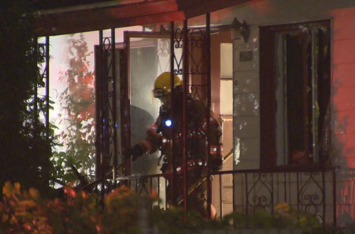 A firefighter exits a home in Longueuil after finding several marijuana plants, Monday, August 31, 2015.
