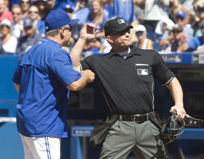 Toronto Blue Jays manager John Gibbons is ejected from the game by home plate umpire Jim Wolf after he came out to complain about Kansas City Royals pitchers throwing at his players in the eighth inning of their AL baseball game in Toronto on Sunday, August 2, 2015. 