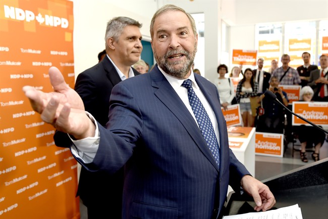 NDP Leader Tom Mulcair speaks to supporters along with candidate Andrew Thomson, left, during a campaign stop in Toronto on Thursday, August 27, 2015. 