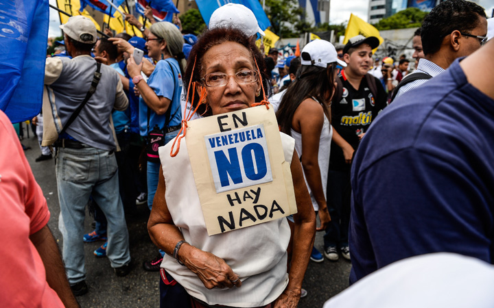 An activist of Venezuela's opposition carries a poster reading "There is Nothing in Venezuela" during a peaceful rally against crime and shortages in the country, in Caracas, on 8 August, 2015. 