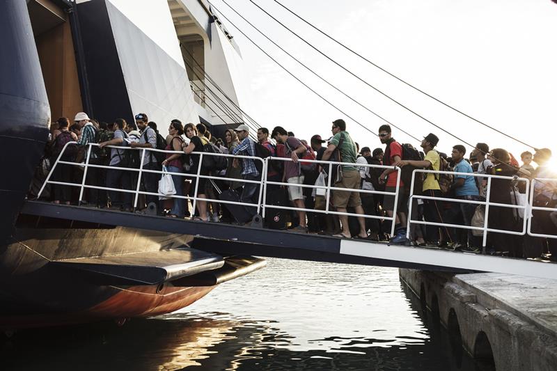Migrants board a ship for Athens at the port of Mytilene on August 14, 2015. The European Union pledged to fast-track new funding to help debt-hit Greece cope with a surge in migrants, with hundreds coming ashore daily only to be confronted by often hellish conditions.