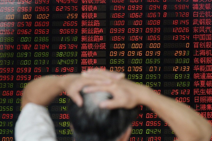 An investor gestures as he checks share prices at a securities firm in Shanghai on August 26, 2015.  