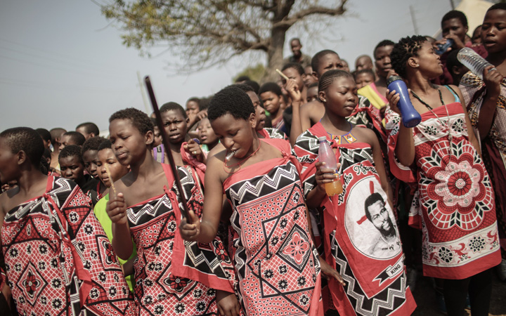 Swazi girls dance and sing as they walk to the Royal palace two day ahead of the traditional reed dance on August 28, 2015 in the outskirts of Luve, Swaziland. 38 young women and girls were killed in a crash on their way to join the festival.