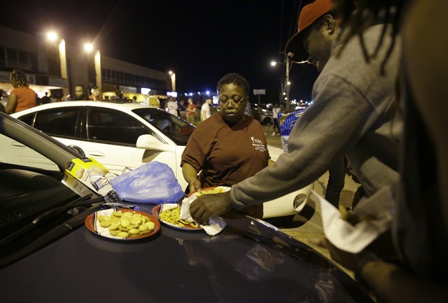 Cat Daniels puts out snacks as smaller group of protesters gather along West Florissant Avenue in Ferguson, Mo., Tuesday, Aug. 11, 2015. The St. Louis suburb has seen demonstrations for days marking the anniversary of the death of 18-year-old Michael Brown, whose shooting death by a Ferguson police officer sparked a national "Black Lives Matter" movement. Tuesday was the fifth consecutive night a crowd gathered on West Florissant.