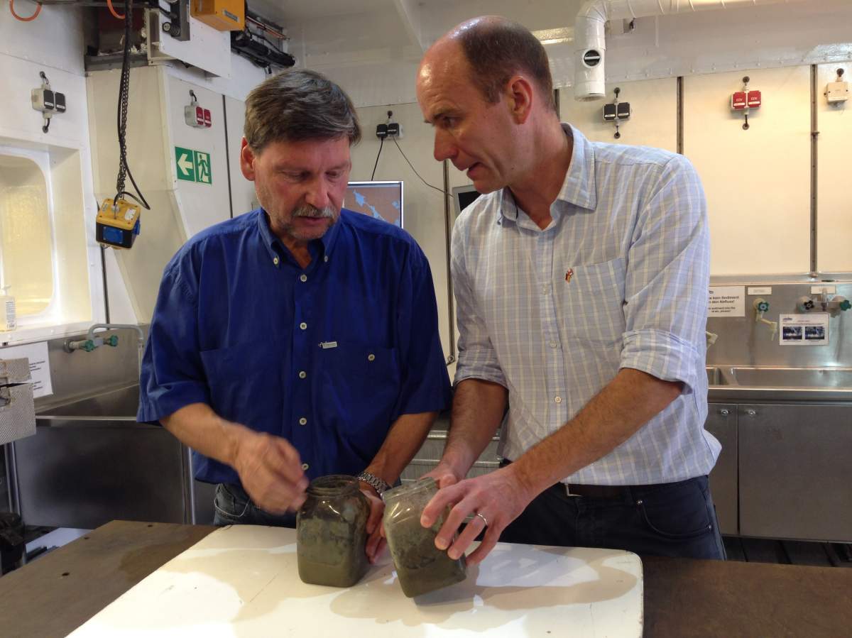 Markus Kienest (R), a professor of oceanography at Dalhousie University and Ralph Schneider (L), chief scientist aboard the Maria S. Merian, look at sediment samples.