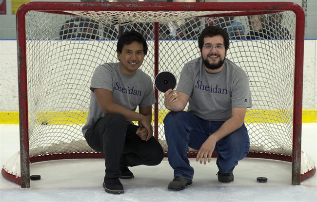 Sheridan College student designers Kristoffer Pascual, right, and Ryan Veiera pose for a portrait with their specially designed hockey puck for the blind on July 30, 2015 in Oakville, Ont. 