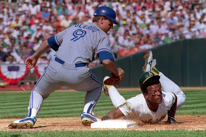 John Olerud tries to tag out Oakland A’s Rickey Henderson in a pick-off attempt at first base on October 12, 1992 in the third inning of game five of the American League Championship Series in Oakland, CA.