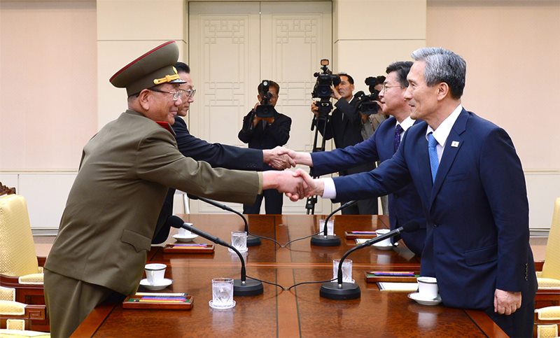 In this photo provided by the South Korean Unification Ministry, South Korean National Security Director, Kim Kwan-jin, right, and Unification Minister Hong Yong-pyo, second from right, shake hands with Hwang Pyong So, left, North Korea' top political officer for the Korean People's Army, and Kim Yang Gon, a senior North Korean official responsible for South Korean affairs, during their meeting at the border village of Panmunjom in Paju, South Korea, Saturday, Aug. 22, 2015. 