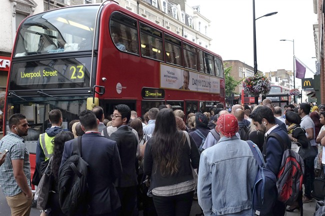 Passengers crowd around a bus stop outside Paddington Station in London, Thursday, Aug. 6, 2015. Commuters are having to find alternative methods of travel Thursday as the London tubes are not running due to a strike. London's mayor has ruled out offering more money to resolve a London Underground labor set to shut down services for the second time this summer. (AP Photo/Kirsty Wigglesworth).