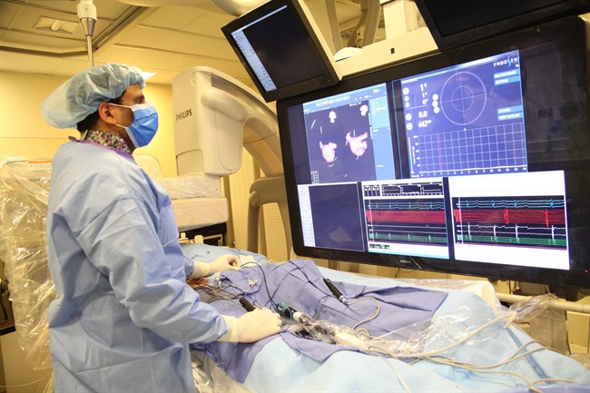 In this undated image provided on Saturday Aug. 29, 2015 by Mount Sinai Hospital in New York shows Dr Vivek Reddy as he checks the screen while doing a surgery to implant the new tiny wireless pacemaker.