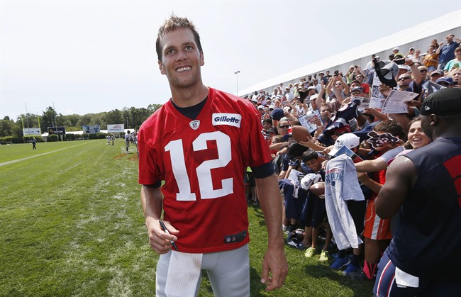 New England Patriots quarterback Tom Brady walks down the line of fans signing autographs during an NFL football training camp in Foxborough, Mass., Saturday, Aug. 1, 2015. 