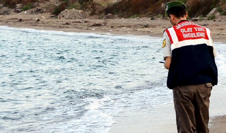 A Turkish officer stands over the body of a young boy, believed to be a Syrian refugee, washed ashore near the Turkish resort of Bodrum on Wednesday.  The original photo can be seen below. Viewer discretion is advised. 