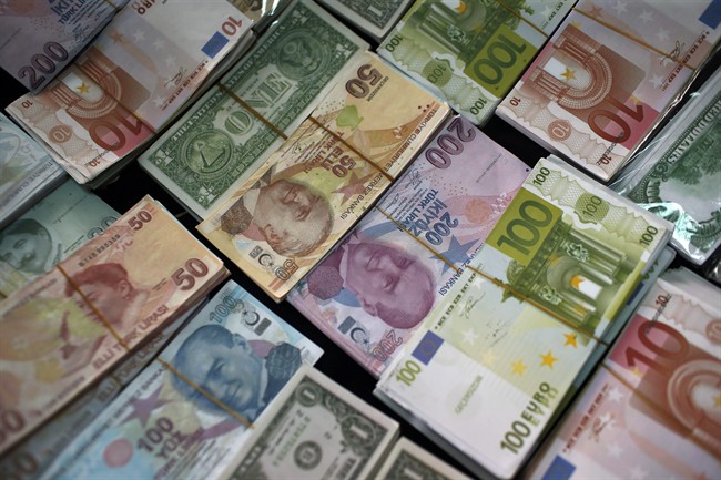 FILE - In this Monday, June 8, 2015 file photo, Turkish Liras, Euros and U.S. Dollars are stacked at a currency exchange office in Istanbul, Turkey.