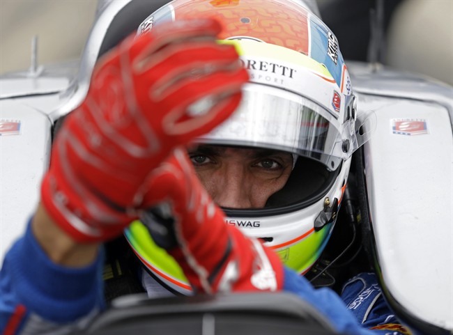 This is a May 14, 2015, file photo showing Justin Wilson, of England, putting on his gloves as he prepares to drive during practice for the Indianapolis 500 auto race at Indianapolis Motor Speedway in Indianapolis. 