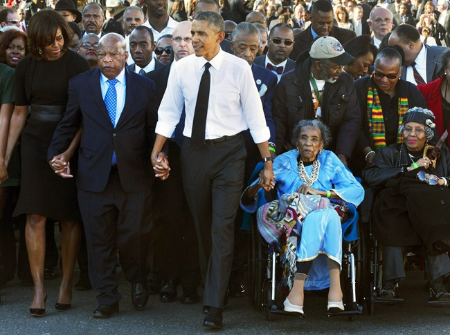 FILE - In this March 7, 2015 file photo, President Barack Obama, center, holds hands with Rep. John Lewis, D-Ga., left, and Amelia Boynton Robinson, right, who were both beaten during "Bloody Sunday," as they walk across the Edmund Pettus Bridge in Selma, Ala., for the 50th anniversary of “Bloody Sunday." Boynton Robinson, a civil rights activist who nearly died while helping lead the Selma march on “Bloody Sunday,” championed voting rights for blacks, and was the first black woman to run for Congress in Alabama, died Wednesday, Aug. 26, 2015. She was 104. Boynton Robinson was hospitalized in July after having a major stroke and turned 104 on Aug. 18. (AP Photo/Jacquelyn Martin, File).
