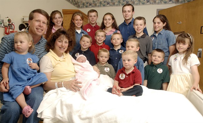 FILE -- In this Aug. 2, 2007 file photo, Michelle Duggar, left, poses with her husband Jim Bob, second from left, and children, including their oldest son Josh, tallest standing, after the birth of her 17th child in Rogers, Ark.