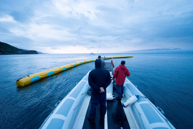 In this March 2014 photo, provided by The Ocean Cleanup shows crew members inspecting a 40-meter long proof-of-concept barrier in Pico Island, Azores, Portugal. 