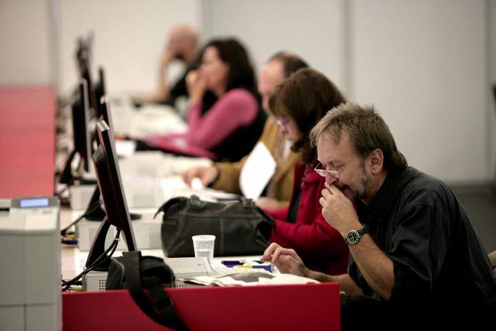 Men and women sit next to each other in office.