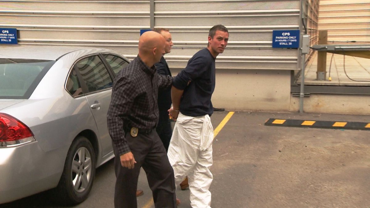 Calgary police officers escort Jonathan Edward Martin into the Arrest Processing Unit on Wednesday, August 26, 2015.