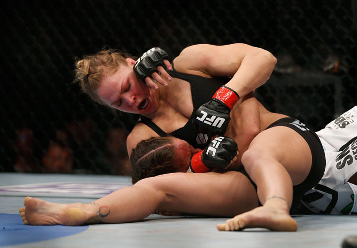 Ronda Rousey, top, grapples with Liz Carmouche during their UFC 157 women's bantamweight championship mixed martial arts match in Anaheim, Calif., Saturday, Feb. 23, 2013.