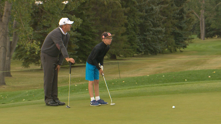 Professional Canadian golfer Jim Rutledge gives some tips to 12 year old Sam Duerr at a junior event ahead of the Shaw Charity Classic.